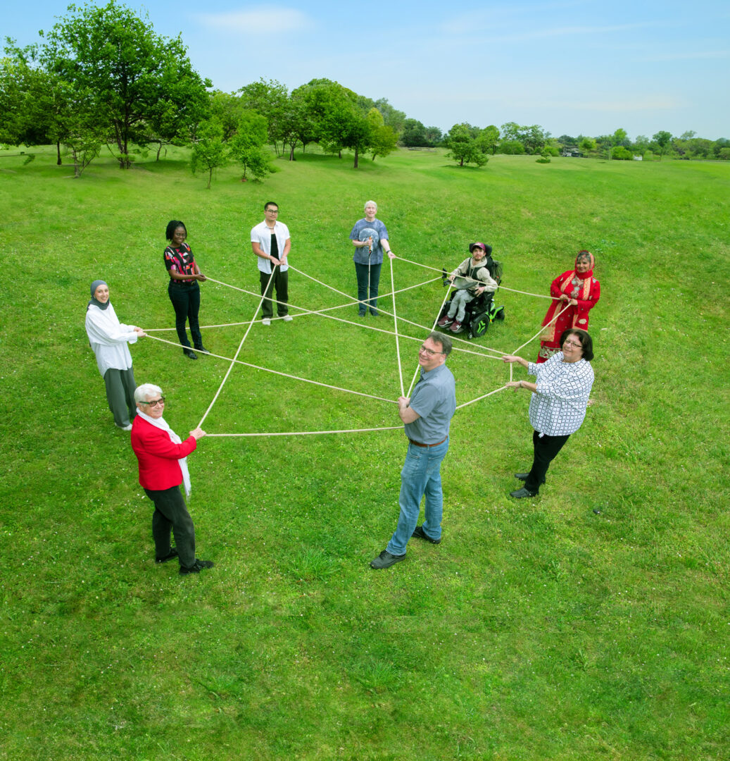 Menschen halten gemeinsam Fäden zu einem Netz